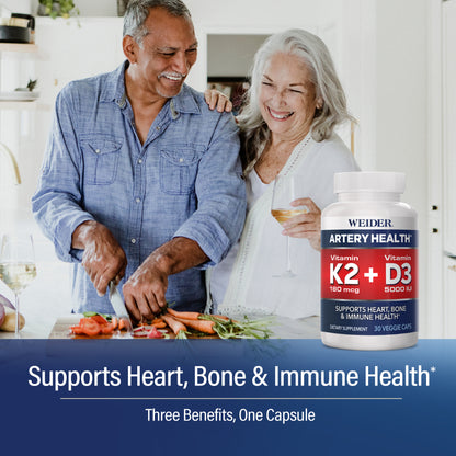 Smiling older couple in a bright kitchen, the man slicing carrots and tomatoes, with the WEIDER Artery Health K2 + D3 bottle. Text: "Supports Heart, Bone & Immune Health*. Three Benefits, One Capsule".