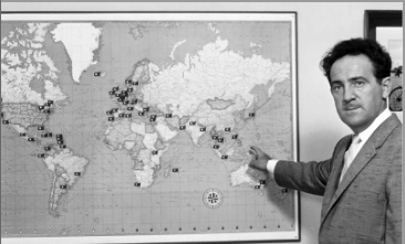 Joe Weider pointing at a world map